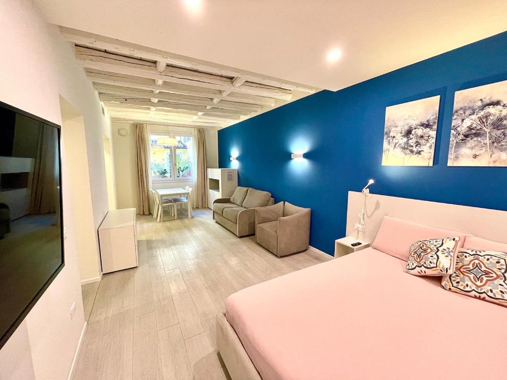 a bedroom with a bed and a living room with a couch at Residenza SubitoSanto - Appartamento 1G "Antenore" in Padova