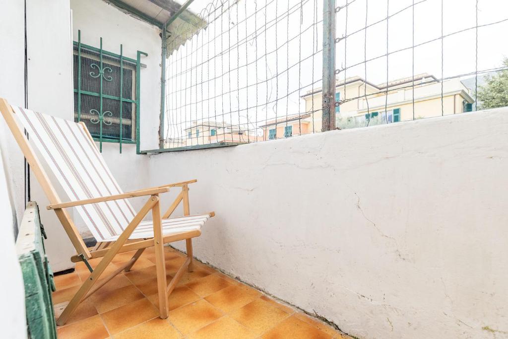 a wooden chair sitting in a room with a window at Levanto lodge in Levanto
