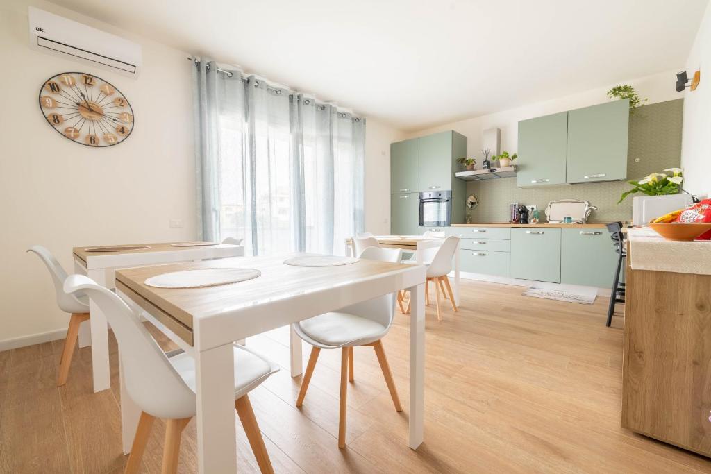 a kitchen and dining room with a white table and chairs at Corona Guest House in Sestu
