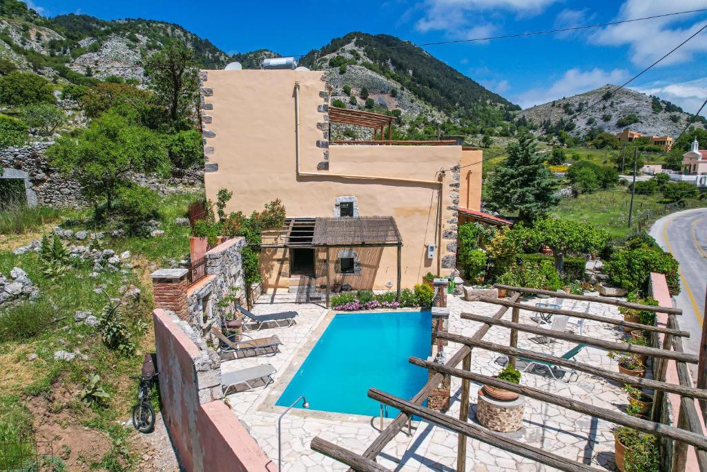 an exterior view of a house with a swimming pool at Traditional Villa with pool in Sfakia in Ímbros