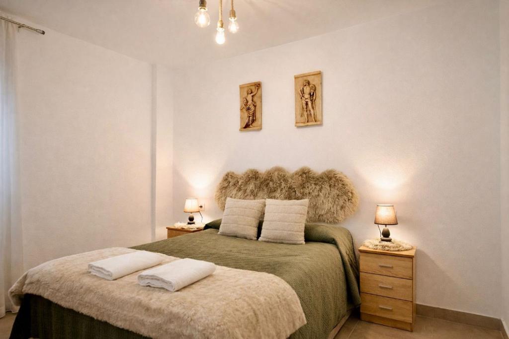a bedroom with a bed with two night stands and two lamps at Arenas del Coliseo Centro Parking Gratis in Mérida
