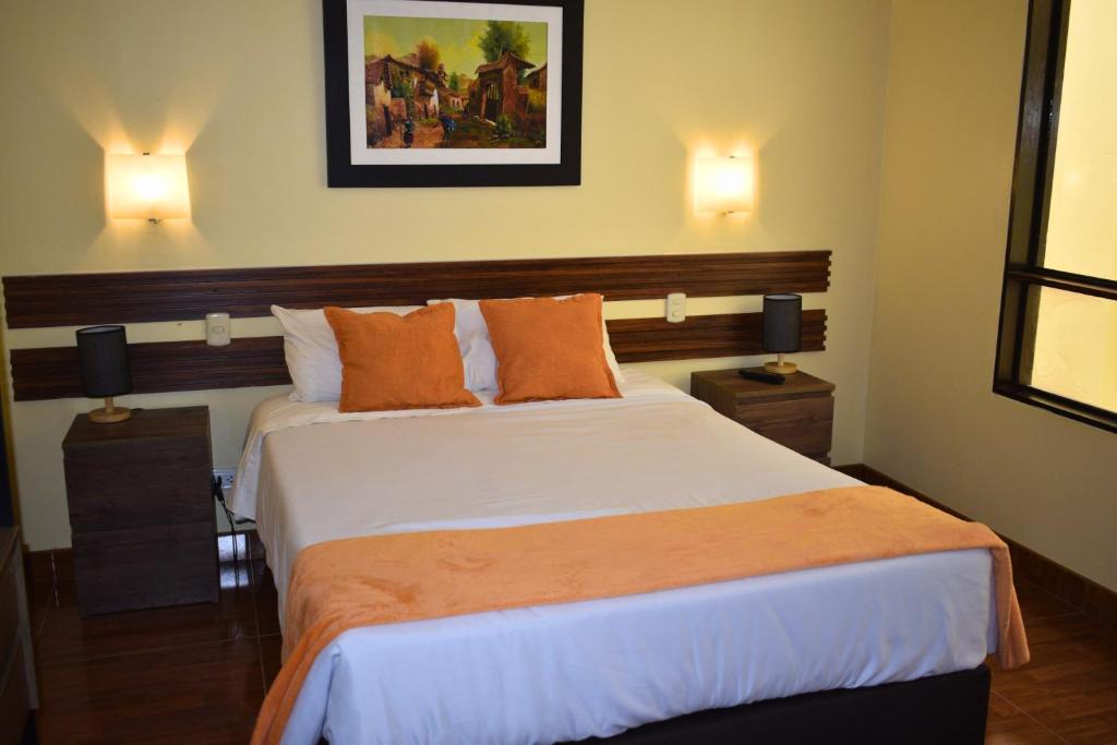 a bedroom with a large bed with orange pillows at Posada Miraflores in Lima