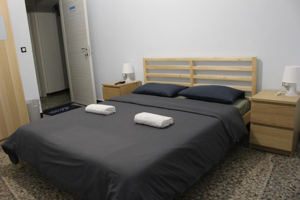 a bedroom with a bed with two towels on it at Uddin House in Genoa