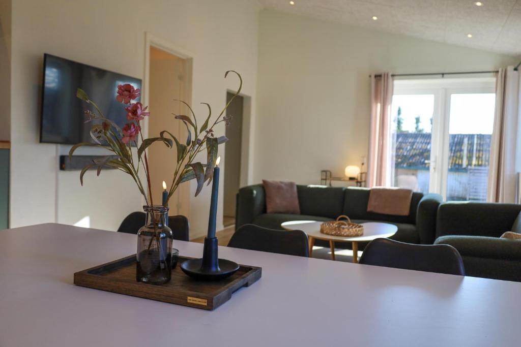 a living room with a table with a vase with flowers at Billund Guest Lodge in Grindsted
