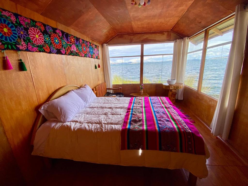 a bedroom with a bed with a large window at Islas Chimu in Puno