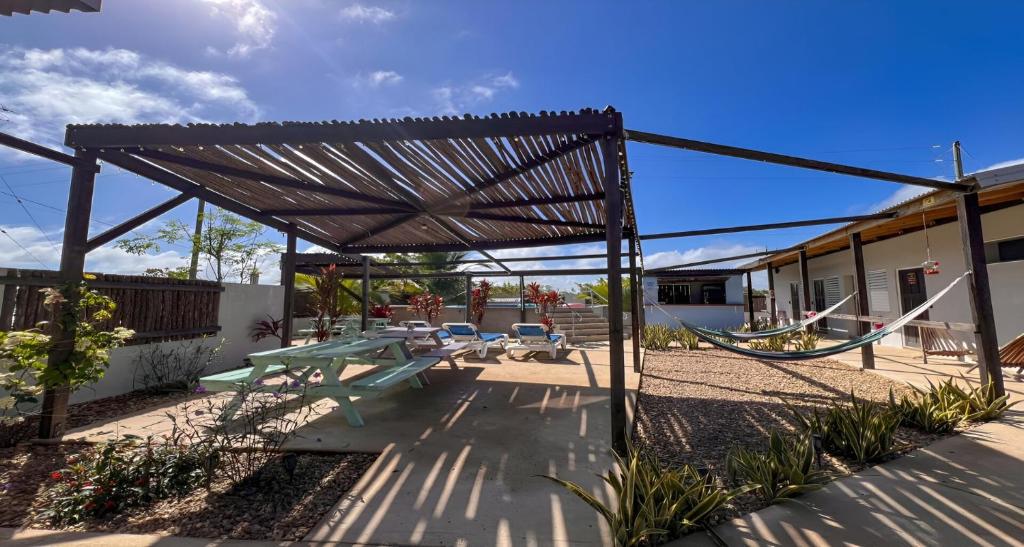 a patio with a picnic table and a swing at Royal Rat Hostel in Placencia