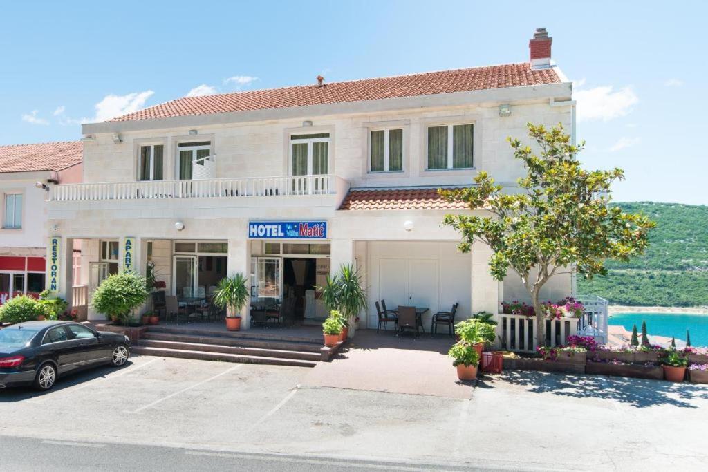 a house with a car parked in front of it at Hotel Villa Matić in Neum