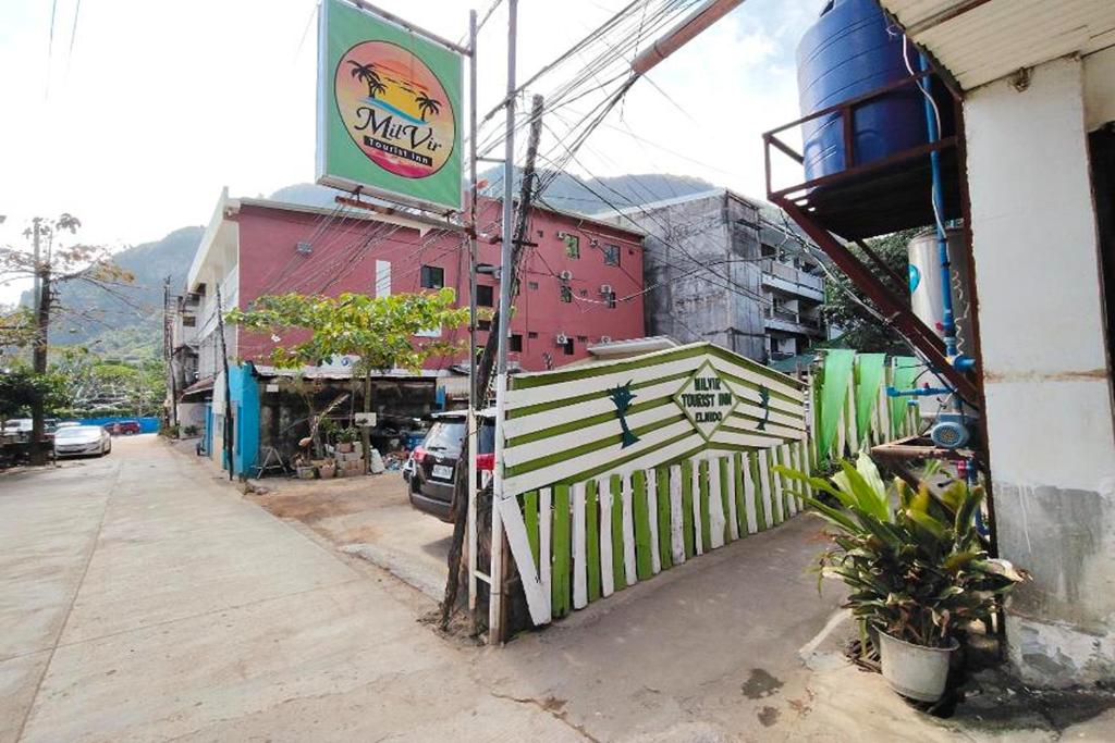 a street with a fence next to a building at MilVir Tourist Inn El Nido near Beach in El Nido