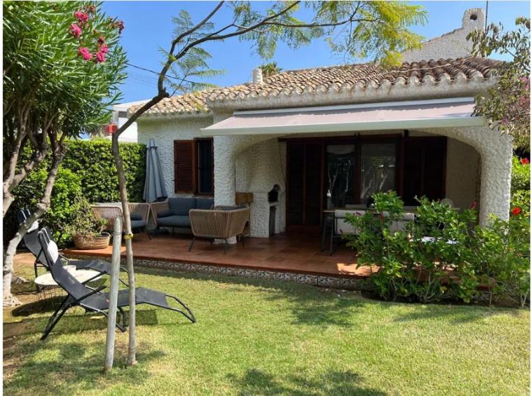 a house with a patio with a table and chairs at Chalet Las Meninas in Denia