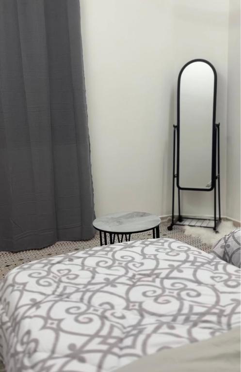 a bedroom with a bed and a mirror at Elite Apartment in Nizwa