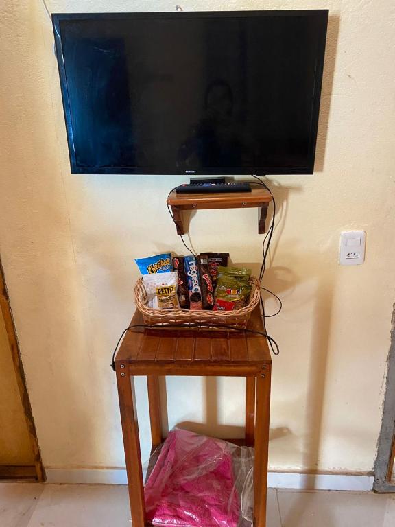 a small table with a television on a wall at Pousada da vila in Beberibe