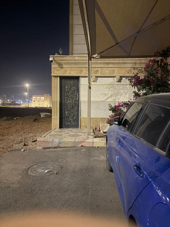 a blue car parked in front of a building at Room In Madinah in Quai