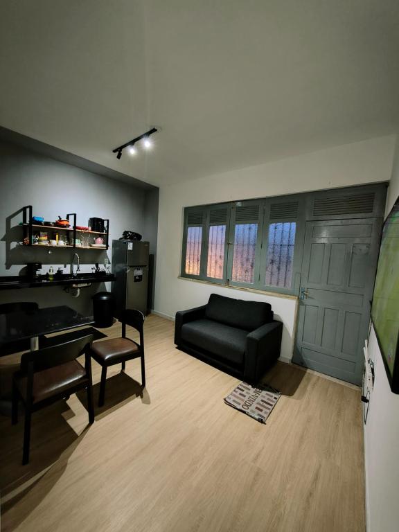 a living room with a black couch and a piano at Ap Umarizal l WiFi 500MB in Belém