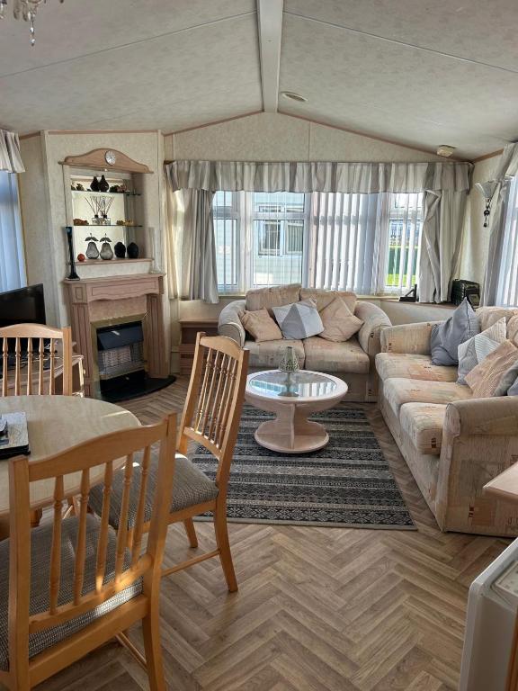 a living room with a couch and a table at 6 berth caravan ensuite the chase in Ingoldmells