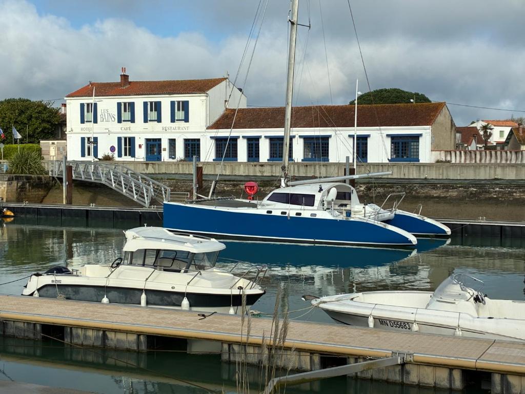 two boats are docked in the water near a building at Les Bains Boyardville - Hôtel et Restaurant in Boyard-Ville