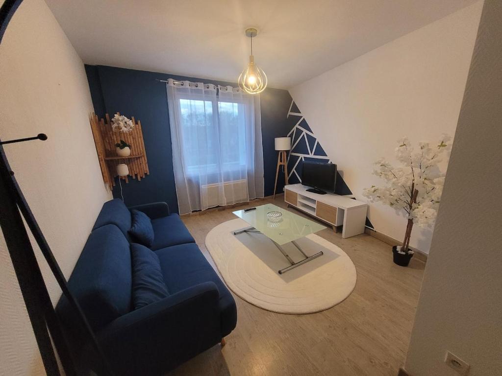 a living room with a blue couch and a table at appartement proche gare SNCF in Tours