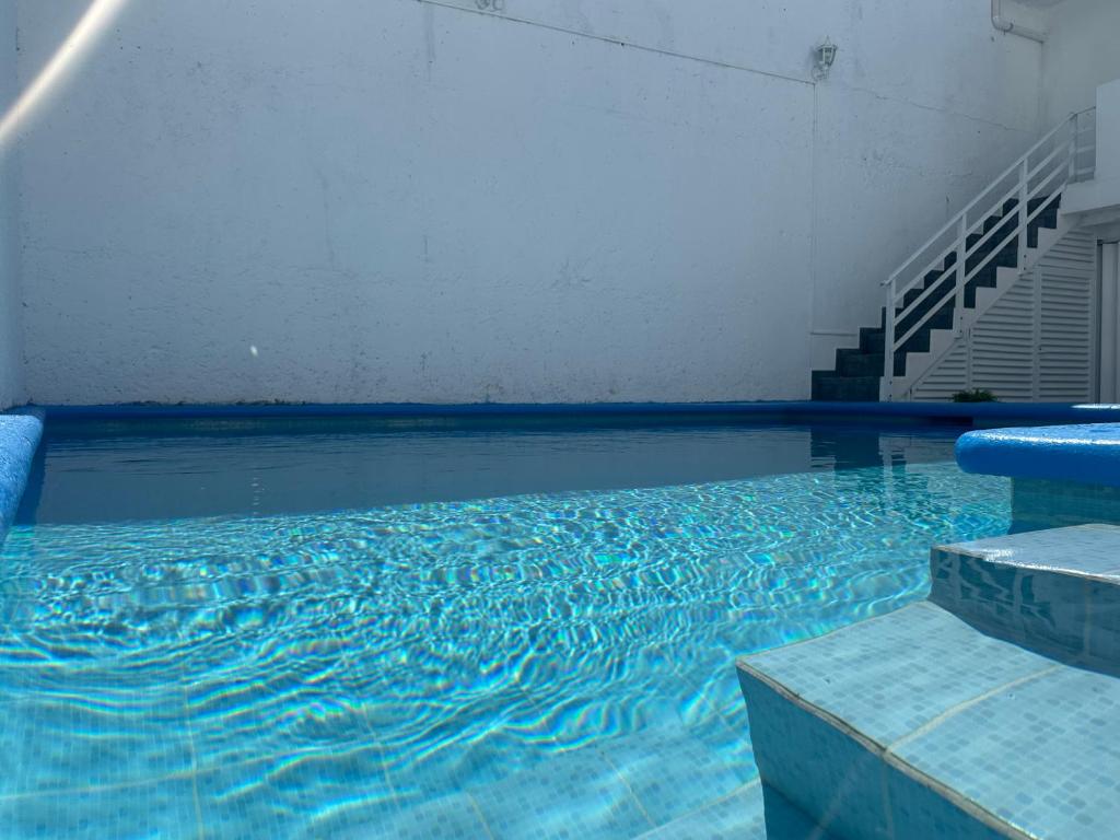 a swimming pool with blue water in a building at Casa Dorada in Cancún