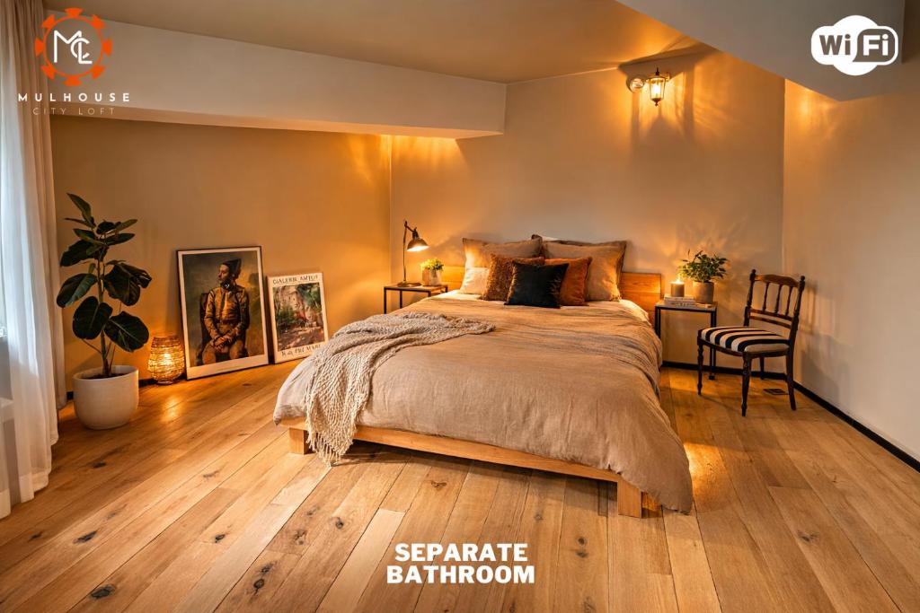 a bedroom with a large bed and wooden floors at Mulhouse City Loft in Mulhouse