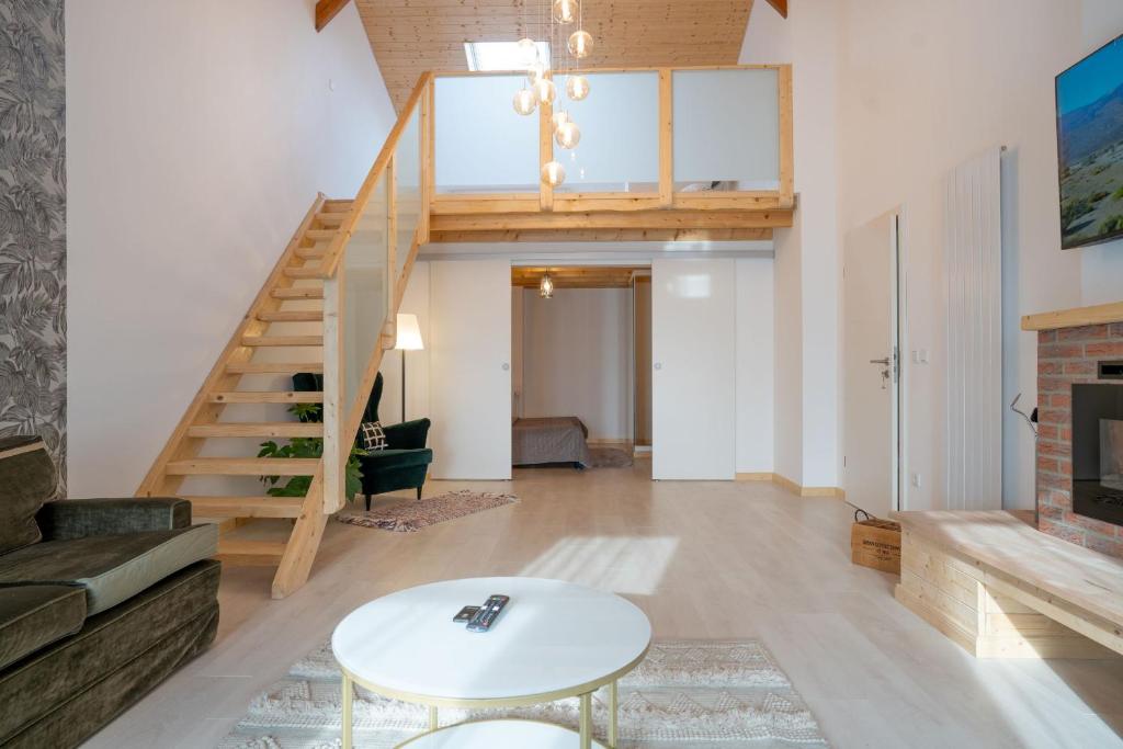 a living room with a staircase and a table at Hof Friesenruhe – Loft in Högel