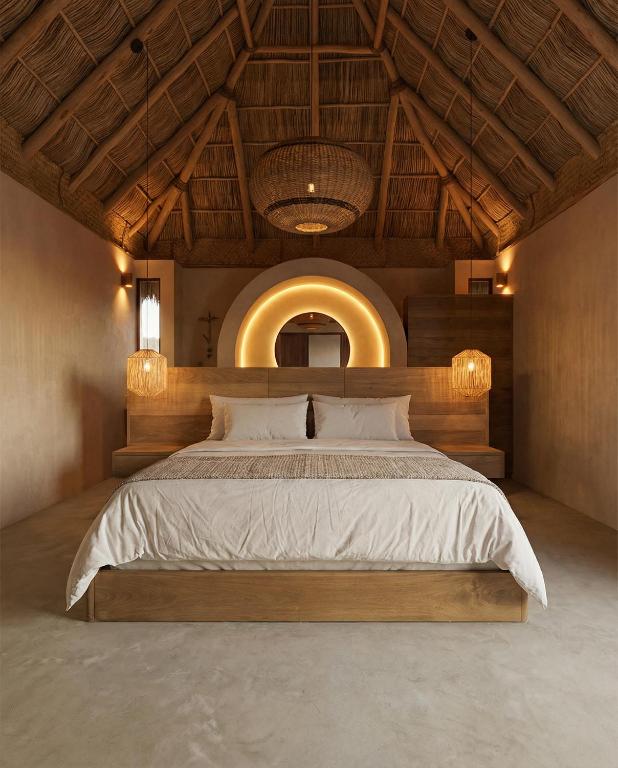 a bedroom with a large bed with a wooden headboard at Mayto Astrological Park in Maito