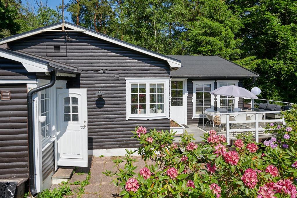 a small house with a porch and a deck at Peaceful Getaway in Åsljunga