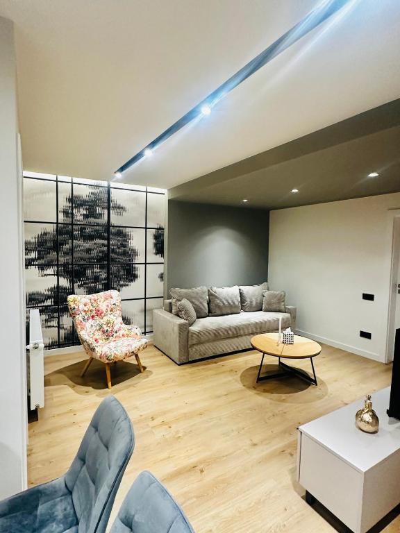a living room with a couch and a table and chairs at Deluxe Aparthotel Central2 in Zalău