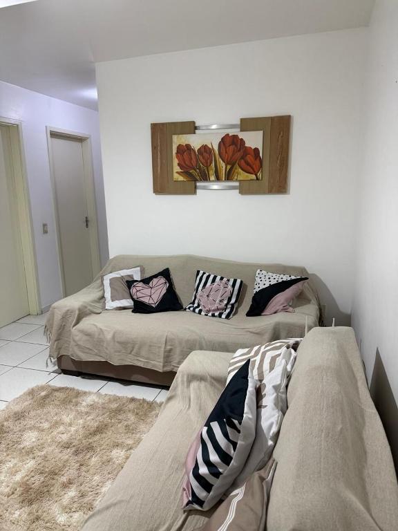a living room with two beds and a couch at Apartamento enseada in Guarujá