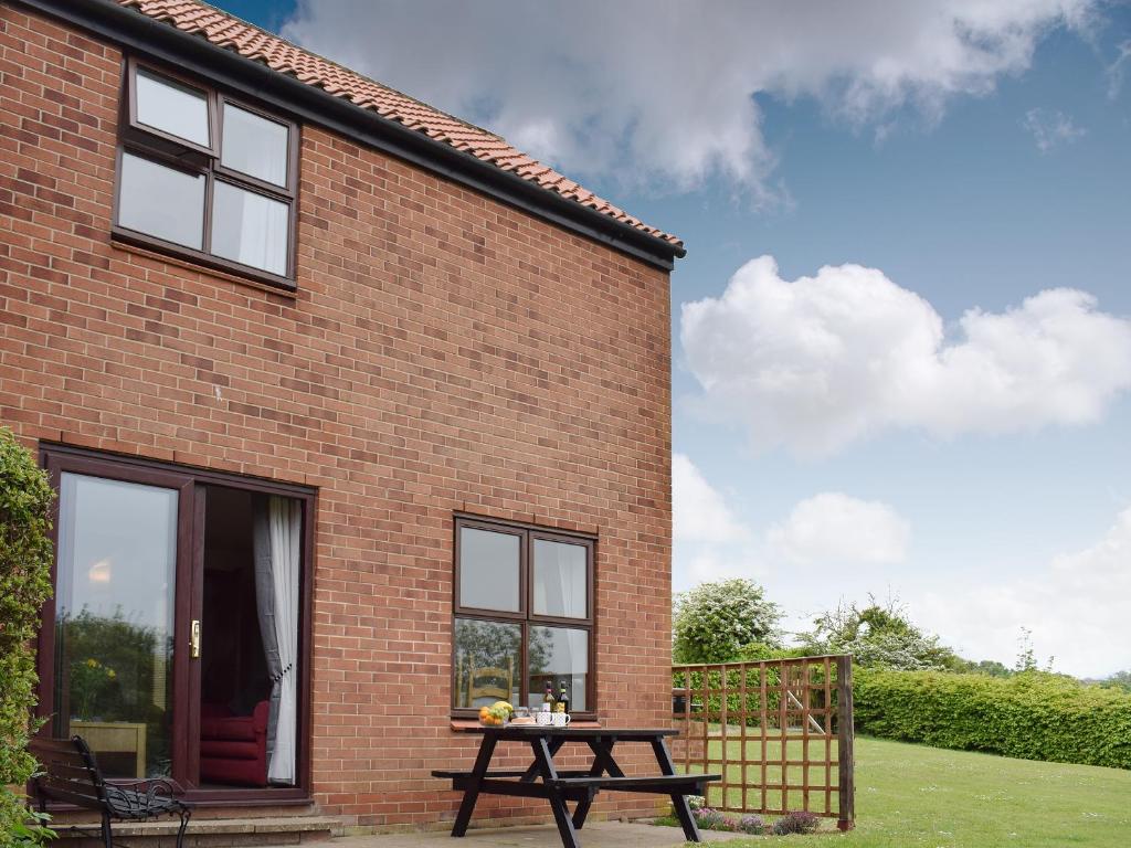 a brick house with a picnic table in front of it at Keel Cottage in Whitby