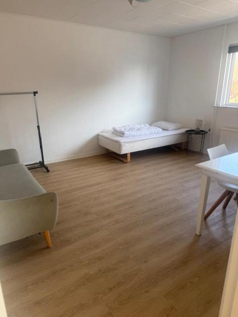 a room with a bed and a chair in it at Havfruens Lejlighed in Rødby