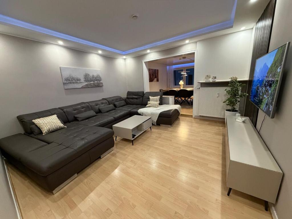 a living room with a black couch and a table at Rheinperle Wesel in Wesel