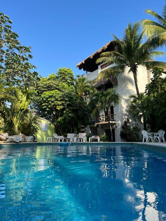 a swimming pool in front of a house at Amazing 2 bedroom condo steps from the beach! in Playa del Carmen