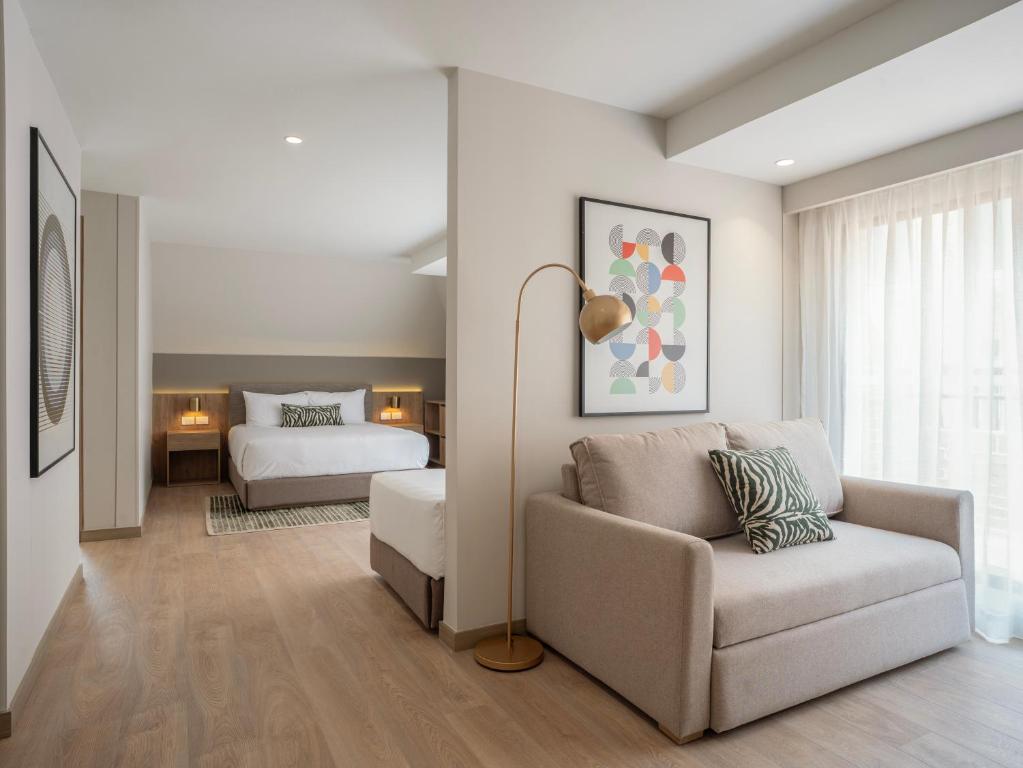 a living room with a couch and a bed at Bomma House - Parque 93 in Bogotá