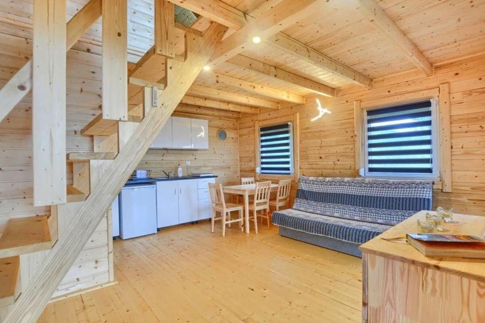 a kitchen and dining room in a wooden cabin at DOMKI u WILKA - Solina Centrum in Solina