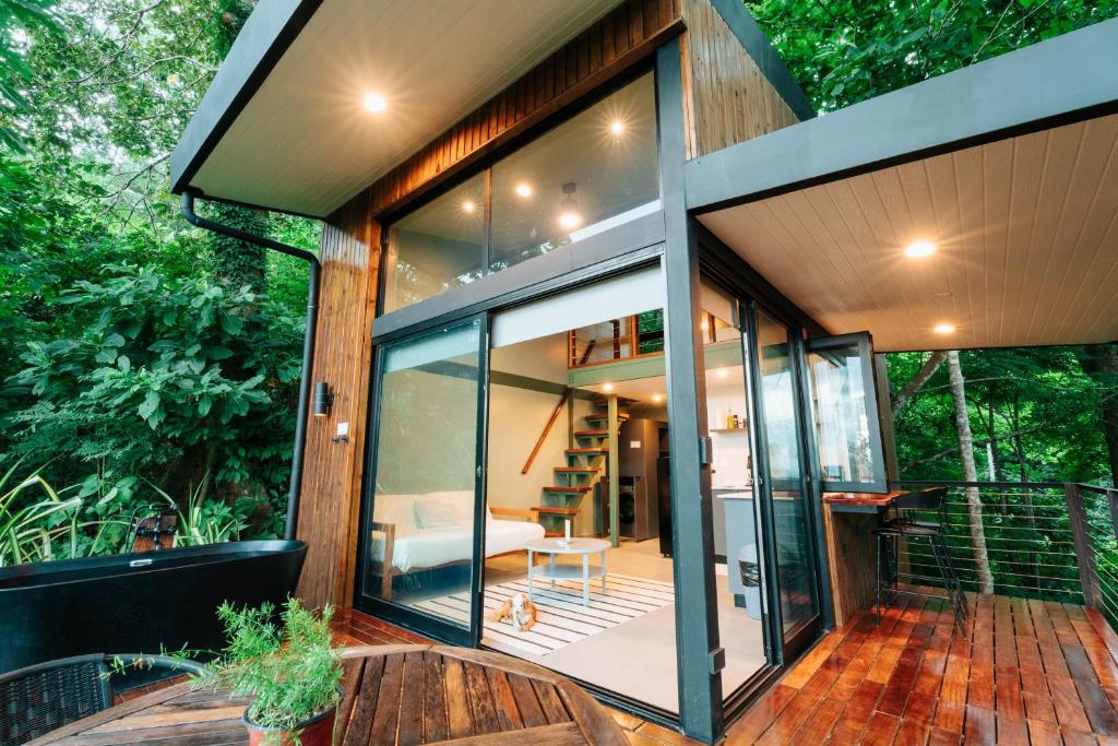 a house with large glass doors on a deck at Stylish Tiny Home with Sea View and Bathtub in Alto del Espino Prieto
