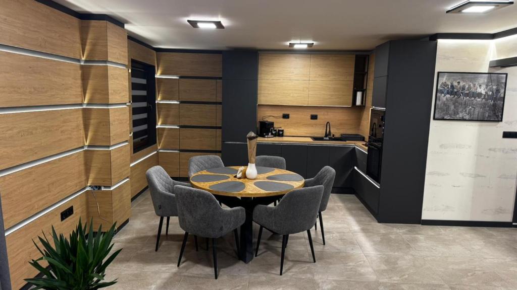 a dining room with a table and chairs and a kitchen at Luxury Apartments TRED in Pleven