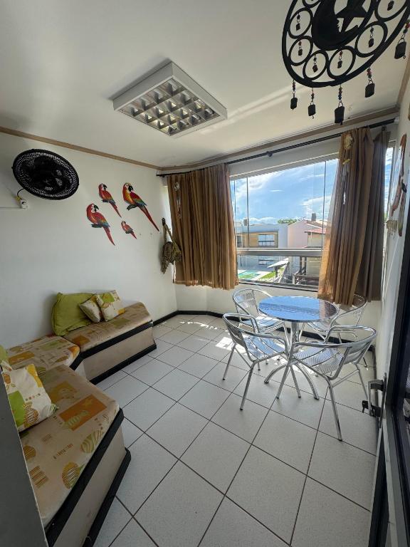 a living room with a table and chairs in it at Apartamento Castelhanos ES in Anchieta