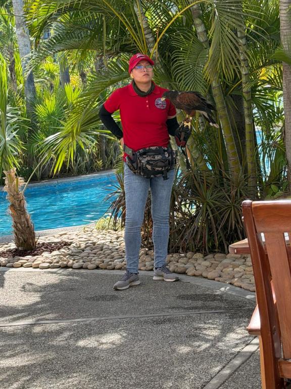 a woman standing next to a tree with a bird at 2bd apartment in Nuevo Vallarta