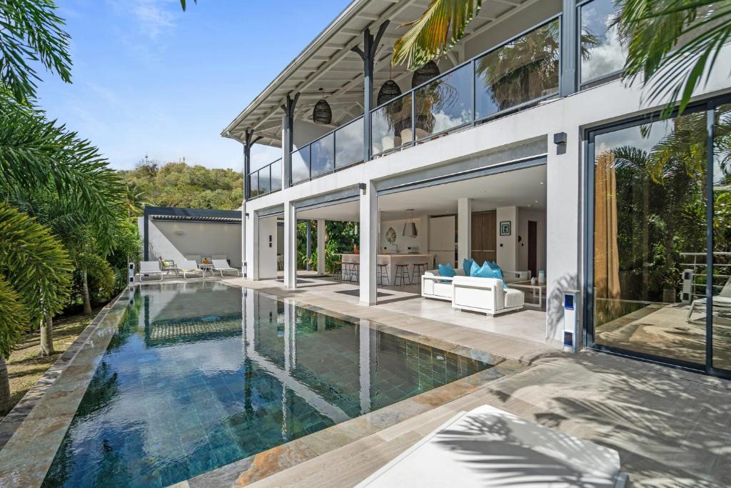 an exterior view of a house with a swimming pool at Villa Ti Karibu in Les Trois-Îlets