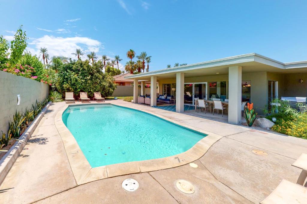 a swimming pool in front of a house at Desert Retreat in Indian Wells