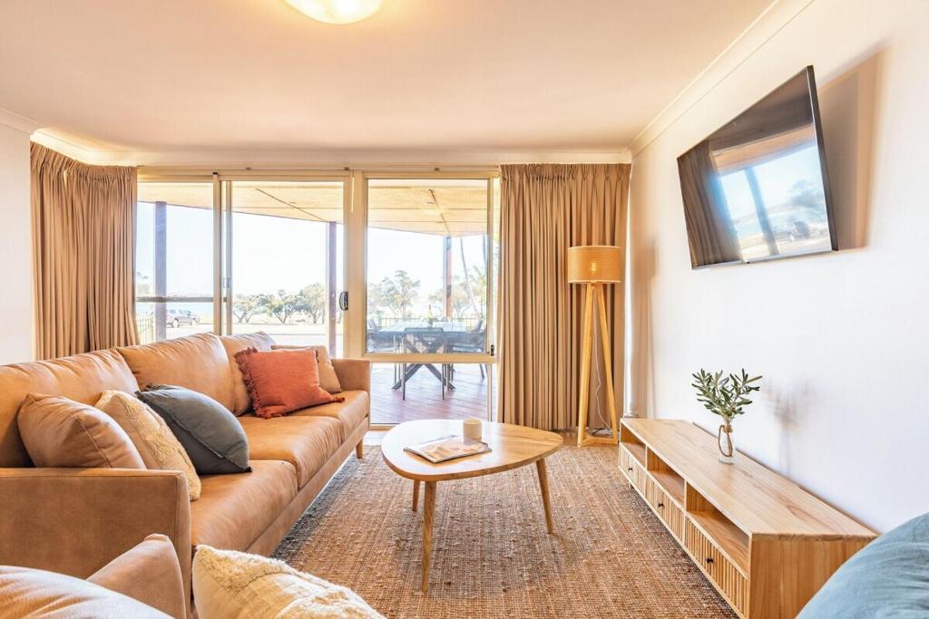 a living room with a couch and a table at Blue Waters - Beachfront and River View - Sleeps 6 -Central Kalbarri in Kalbarri