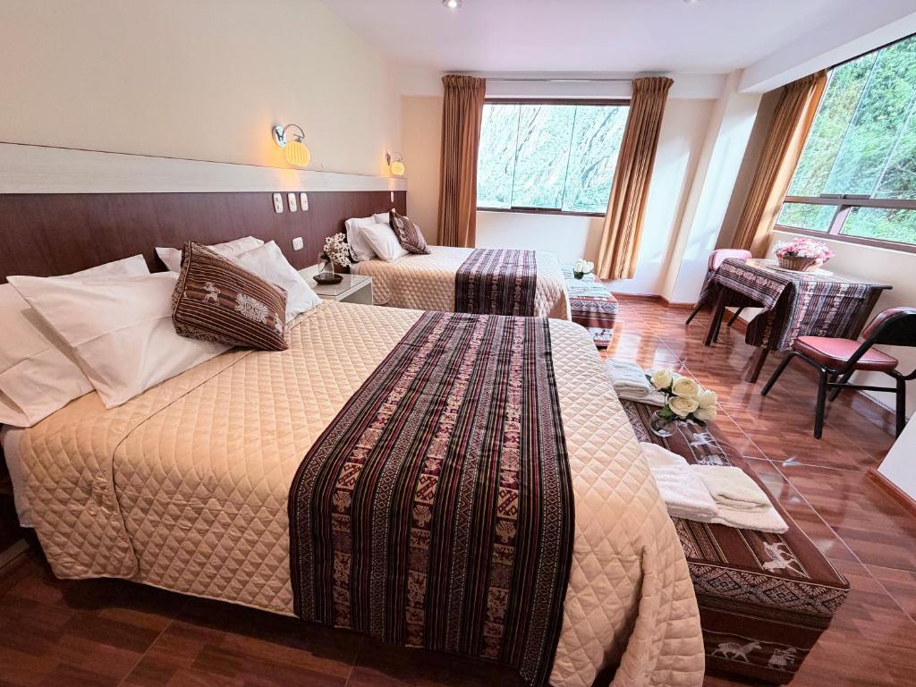a hotel room with two beds and a living room at Boutique Inka Hotel in Ollantaytambo
