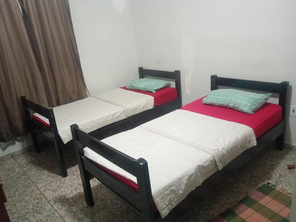 two twin beds in a room with at Hotel Pousada na Br 040 in Valparaíso de Goiás