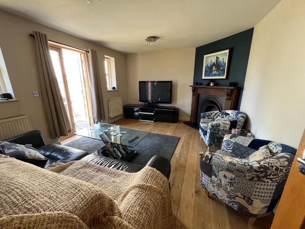 a living room with two couches and a tv at Silsoe Cottage BB Master Suite in Bedford