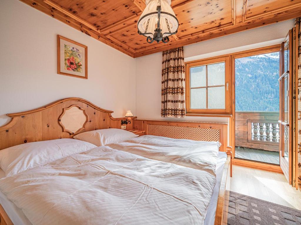 a bedroom with a bed and a large window at Andre Top 2 in Wald im Pinzgau