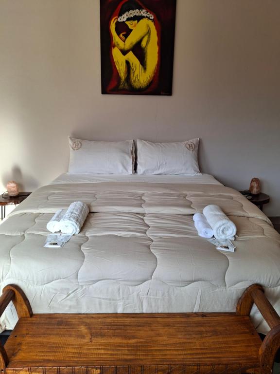 a large bed with white sheets and towels on it at Cabaña los amarillos in Huacalera