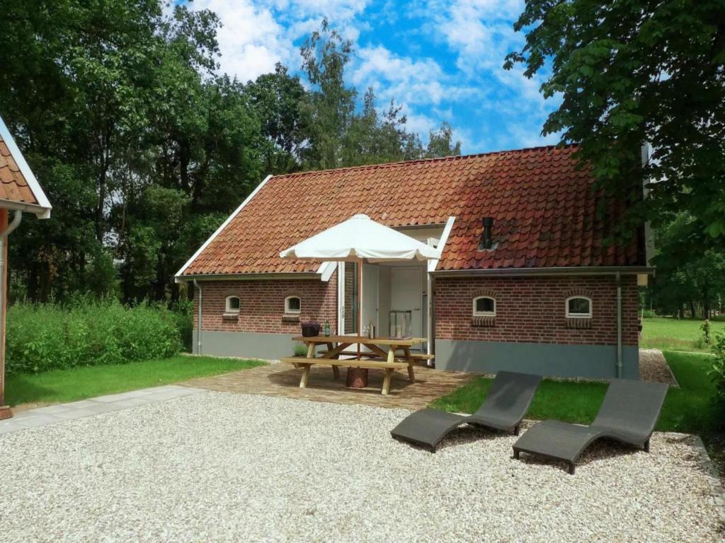 a patio with a picnic table and an umbrella at Design Lodge Twente in Haaksbergen