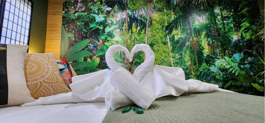 two white swans sitting on top of a bed at Zen Retreat-Jacuzzi, kitchenette, Walk to fun in Reno
