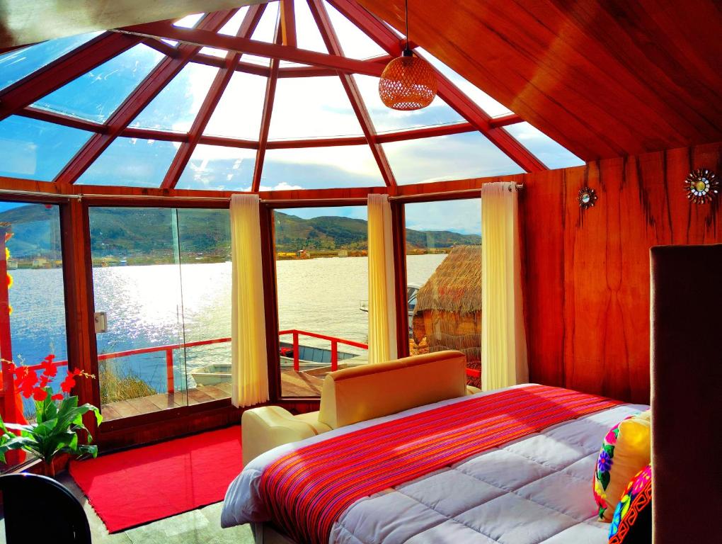 a bedroom with a large window with a bed and a chair at Titikaka sky view lodge in Puno