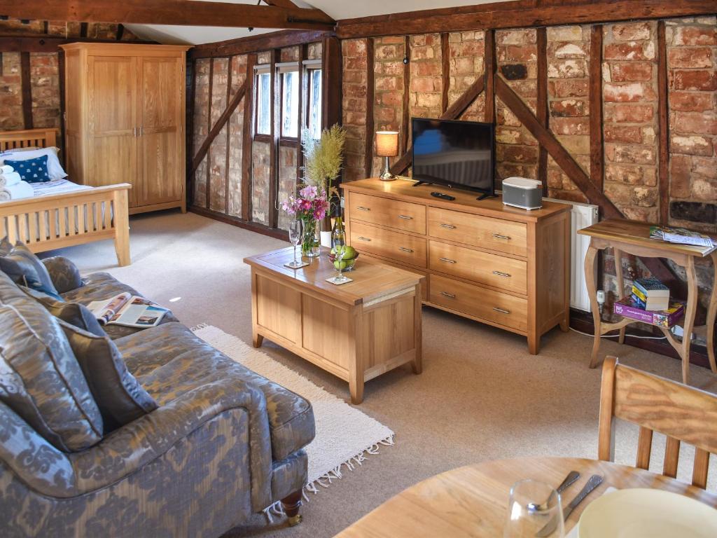 a living room with a couch and a tv at Cartlodge Loft in Roydon