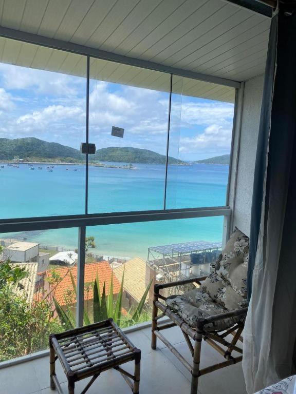a room with a view of the ocean from a window at Pousada Mirante do Atalaia Oficial II in Arraial do Cabo